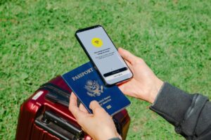 Mão segurando um smartphone usando aplicativo de planejamento de viagem.