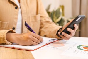 Pessoa segurando um smartphone com aplicativo de lista de tarefas aberto na tela